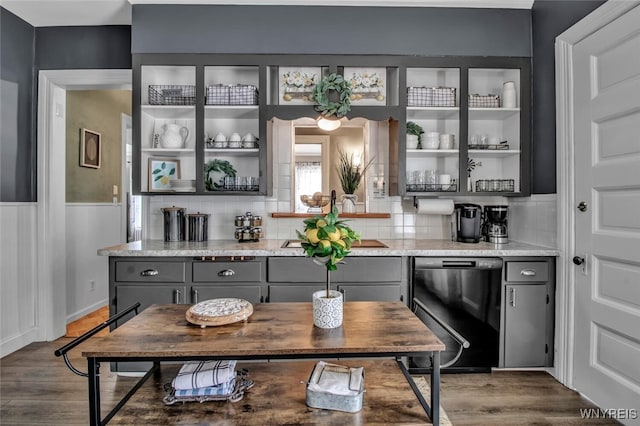 bar featuring gray cabinets, wood-type flooring, black dishwasher, decorative backsplash, and light stone countertops