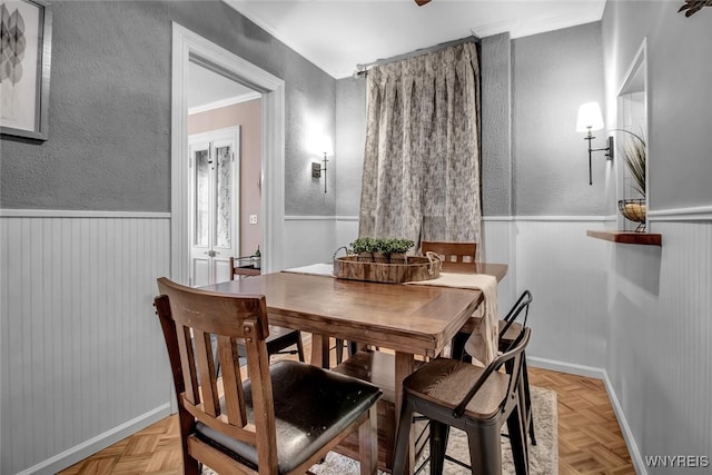 dining space with light parquet floors and ornamental molding