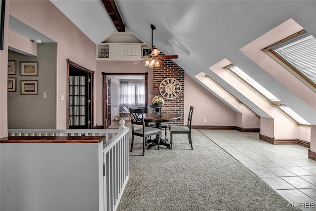 tiled dining room featuring lofted ceiling with skylight and ceiling fan