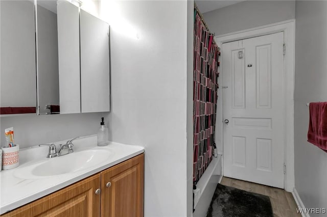 bathroom featuring vanity, wood-type flooring, and shower / bathtub combination with curtain