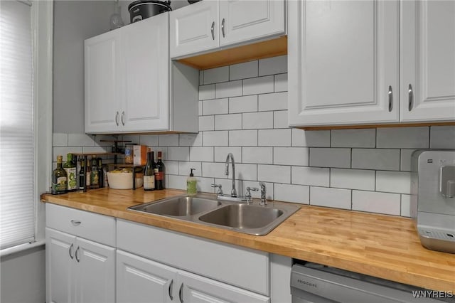 kitchen with dishwasher, sink, and white cabinets