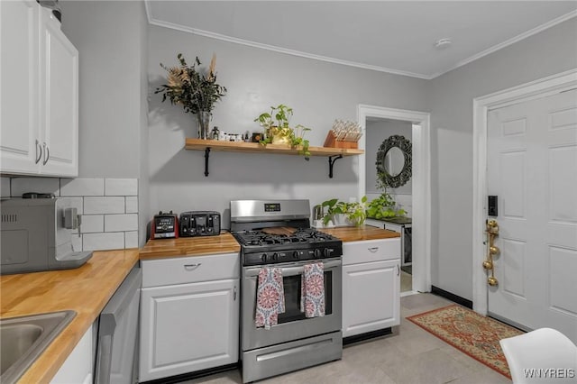 kitchen featuring butcher block countertops, crown molding, stainless steel appliances, white cabinets, and decorative backsplash