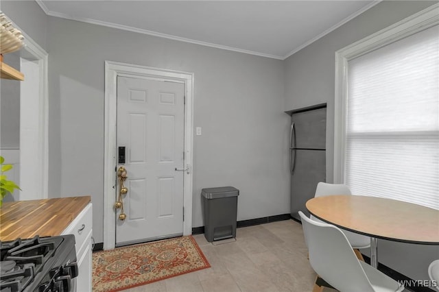 tiled dining area featuring crown molding