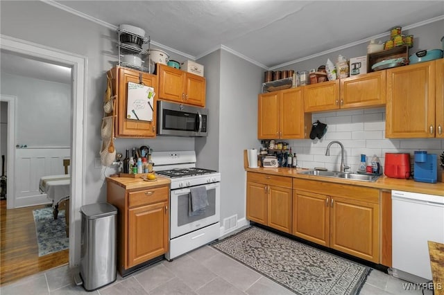 kitchen with ornamental molding, sink, white appliances, and decorative backsplash