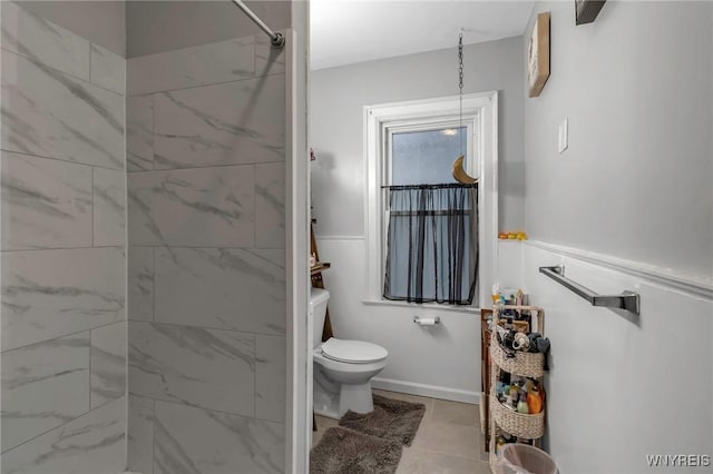 bathroom featuring a tile shower and toilet