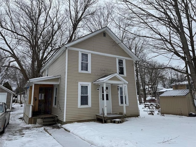 view of front of property featuring a storage shed