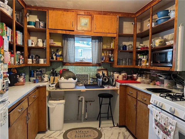 kitchen with white range with gas stovetop and black microwave