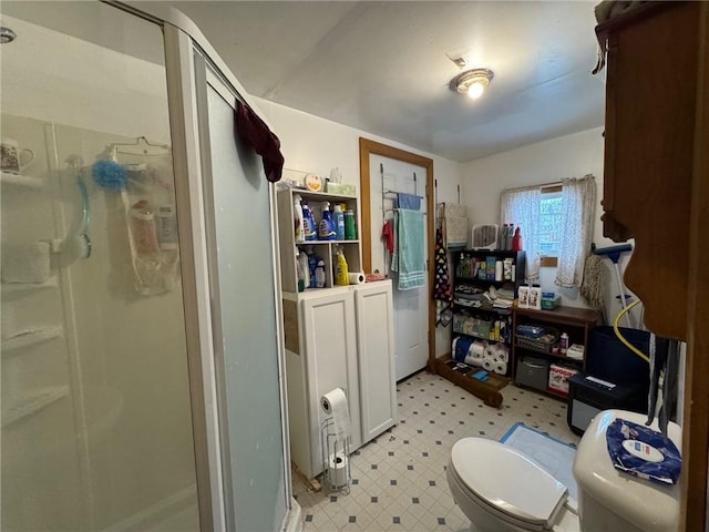 bathroom with toilet and a shower with shower door