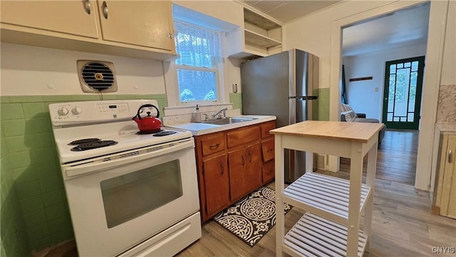 kitchen featuring sink, white electric range, and light hardwood / wood-style flooring