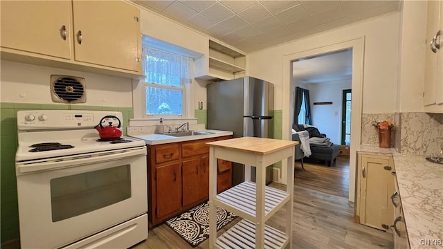 kitchen featuring tasteful backsplash, sink, white electric stove, and light hardwood / wood-style floors