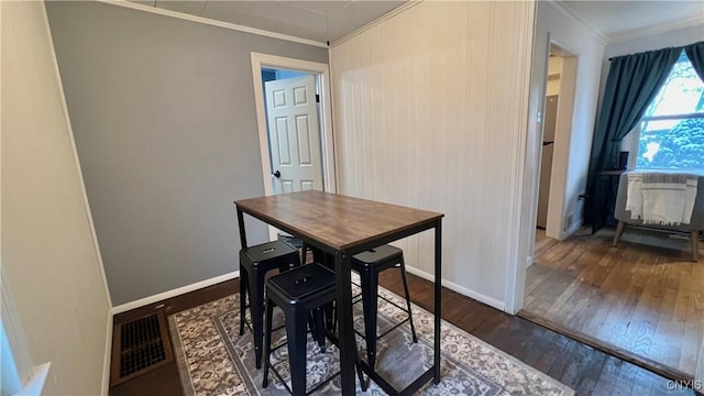 dining space with crown molding and dark hardwood / wood-style flooring