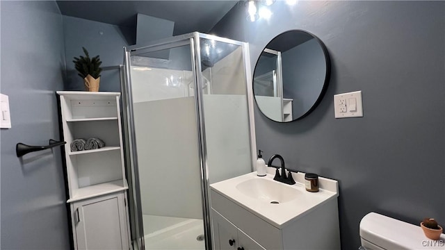 bathroom featuring vanity, a shower with shower door, and toilet