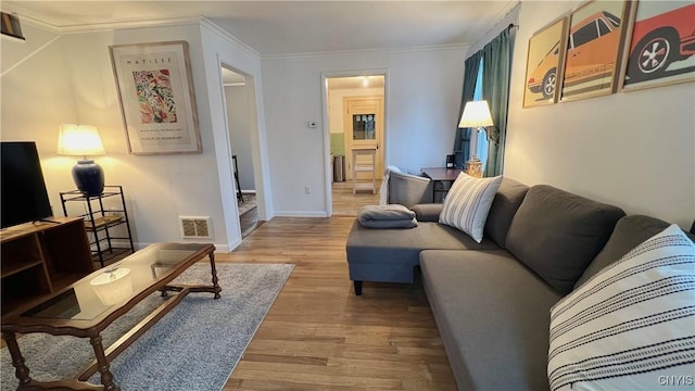 living room with crown molding and light hardwood / wood-style floors