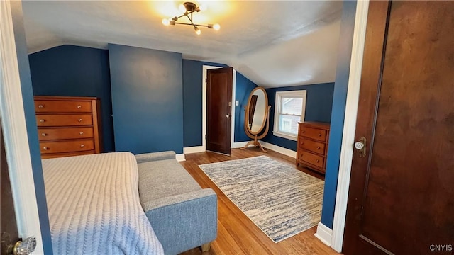 bedroom featuring hardwood / wood-style flooring and vaulted ceiling