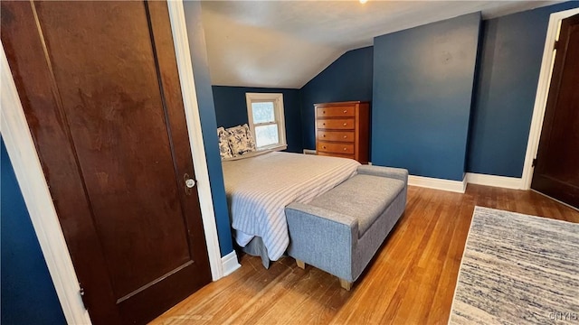 bedroom with lofted ceiling and hardwood / wood-style floors