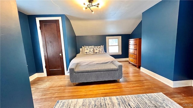 bedroom with lofted ceiling and hardwood / wood-style floors