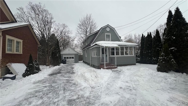 view of front of home with a garage and an outbuilding