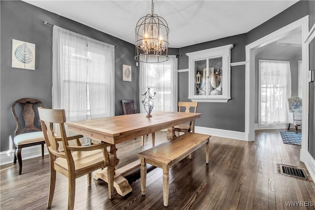 dining area with an inviting chandelier, hardwood / wood-style flooring, and a healthy amount of sunlight