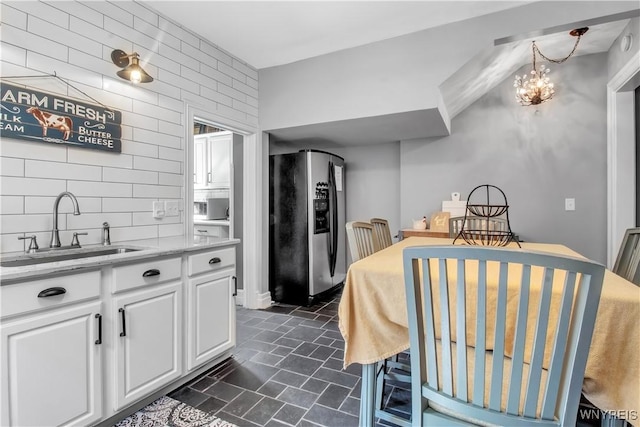 kitchen featuring white cabinetry, sink, stainless steel fridge, and tasteful backsplash