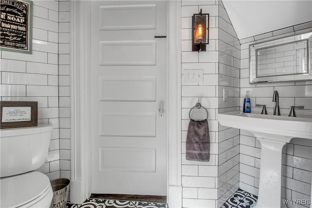 bathroom with tile walls and toilet