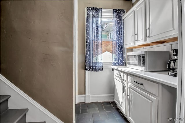 interior space featuring tasteful backsplash, a healthy amount of sunlight, and white cabinets