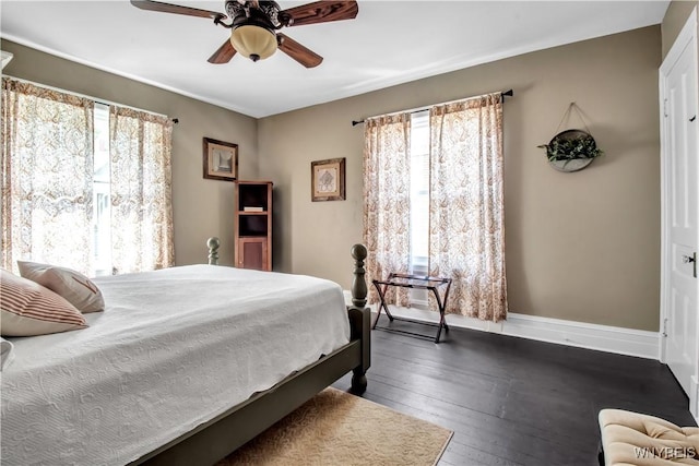 bedroom with multiple windows, dark wood-type flooring, and ceiling fan