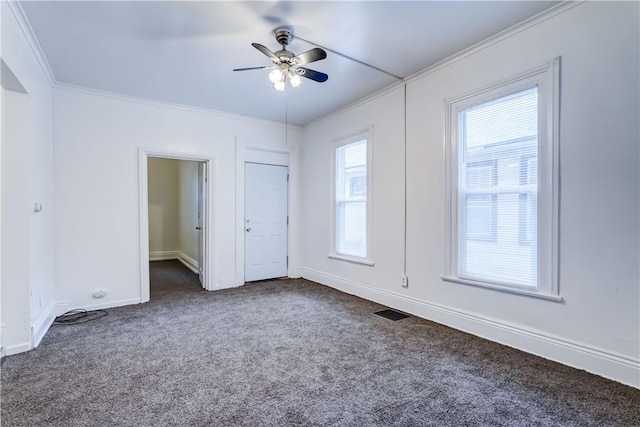 unfurnished room with dark colored carpet, ornamental molding, and ceiling fan