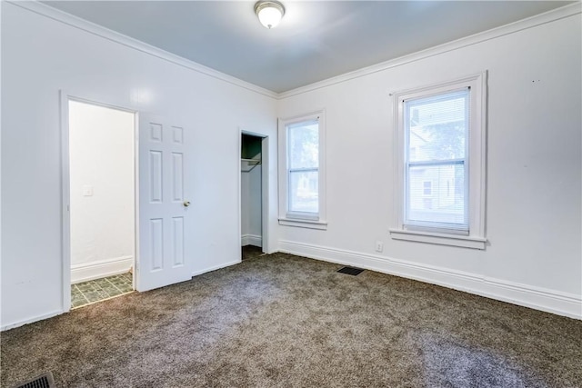 unfurnished room with plenty of natural light, ornamental molding, and carpet flooring