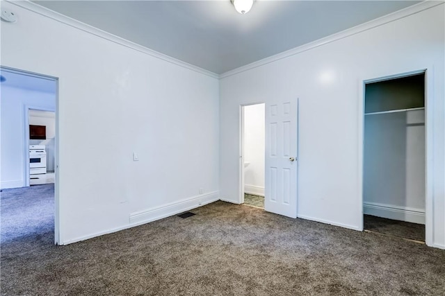 unfurnished bedroom with crown molding, dark carpet, and a closet