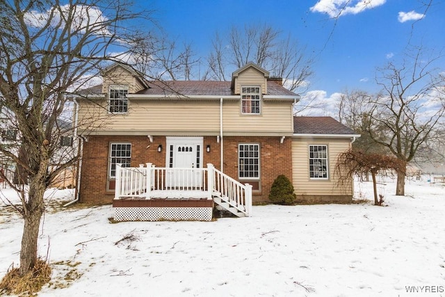 snow covered house featuring a wooden deck