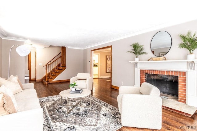 living room featuring dark hardwood / wood-style flooring, a fireplace, ornamental molding, and decorative columns