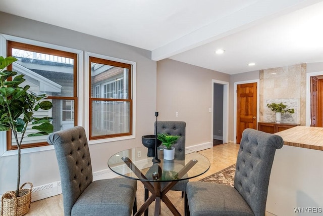 dining space featuring beamed ceiling