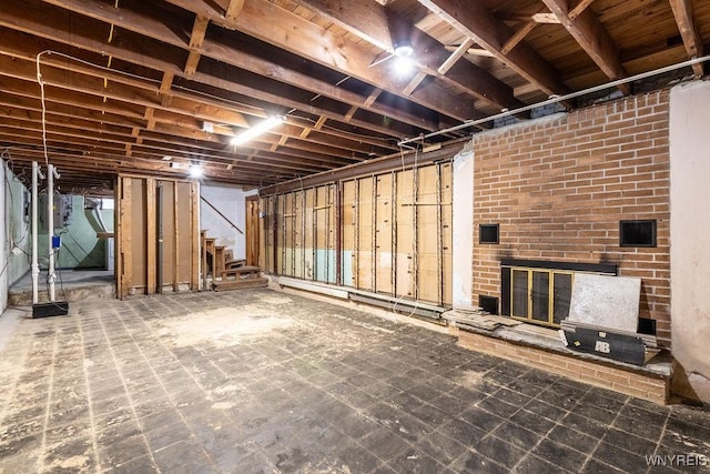 basement featuring a brick fireplace