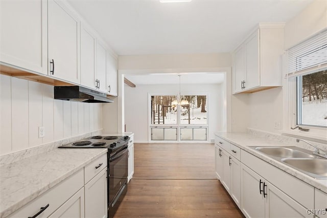 kitchen with white cabinets, black range with electric stovetop, wood finished floors, under cabinet range hood, and a sink