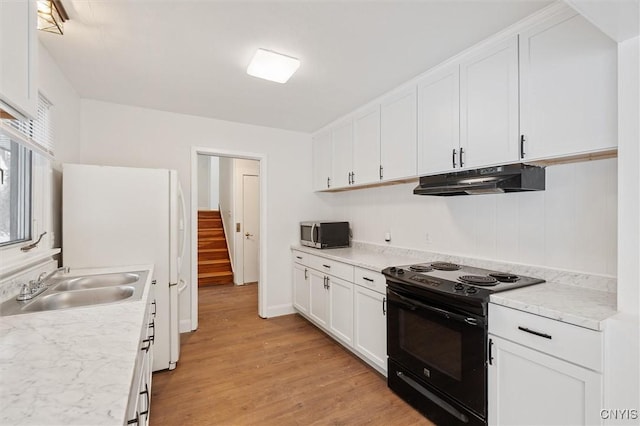 kitchen with under cabinet range hood, black range with electric stovetop, a sink, white cabinets, and stainless steel microwave