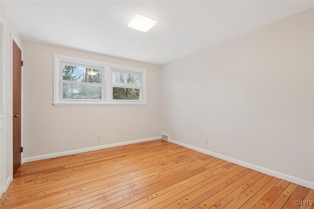 spare room featuring visible vents, light wood-style flooring, and baseboards