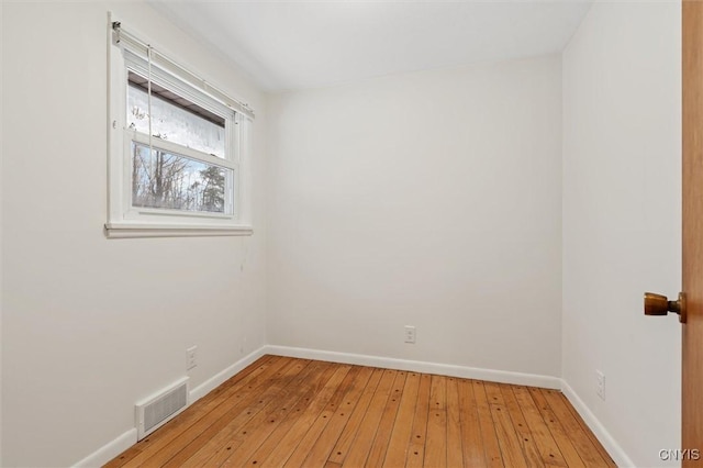 spare room with light wood-type flooring, baseboards, and visible vents