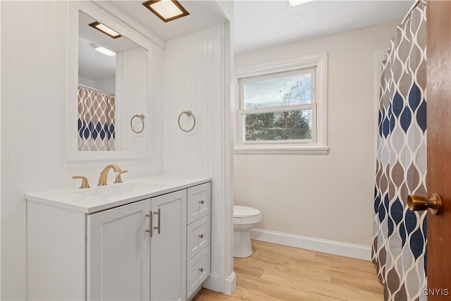 full bathroom with toilet, baseboards, wood finished floors, and vanity