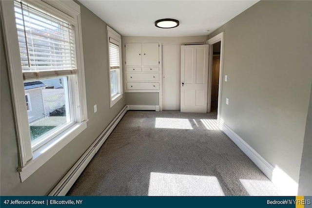 carpeted spare room featuring baseboard heating