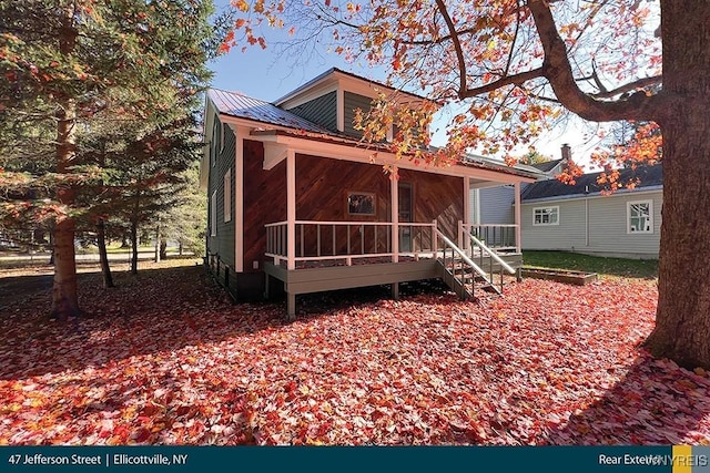 rear view of property with covered porch and metal roof