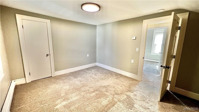 carpeted empty room with baseboards and baseboard heating