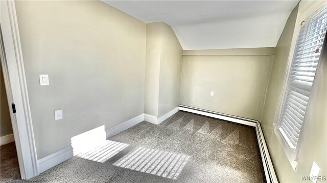 interior space featuring carpet floors, baseboard heating, a baseboard heating unit, vaulted ceiling, and baseboards