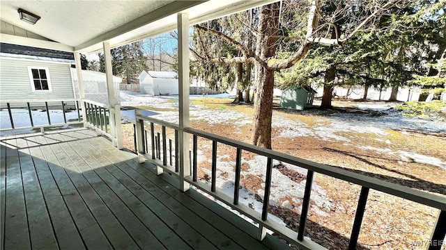 wooden deck featuring an outbuilding and a storage unit