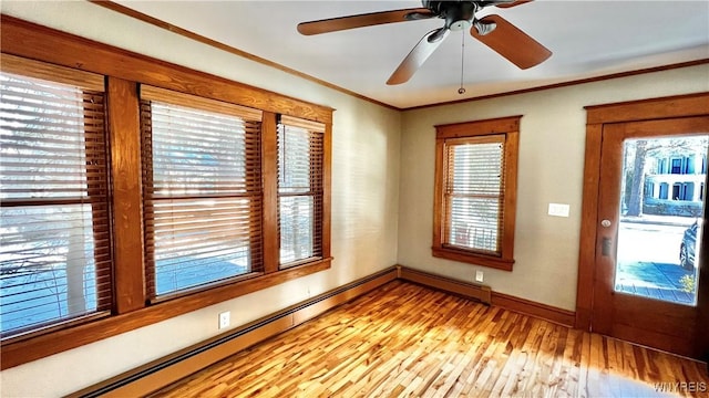 unfurnished room featuring light wood-type flooring, baseboards, crown molding, and baseboard heating