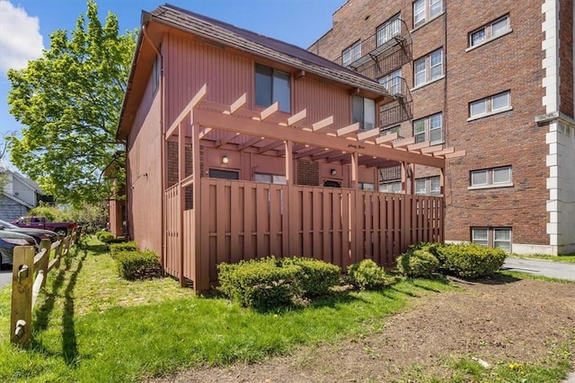 exterior space with a pergola and a lawn