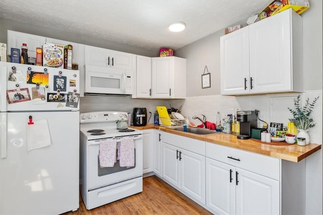 kitchen featuring wood counters, sink, light wood-type flooring, white cabinets, and white appliances