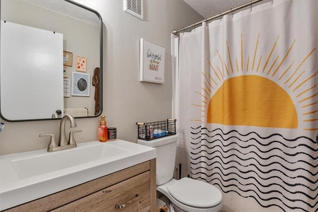 bathroom with vanity, a textured ceiling, and toilet