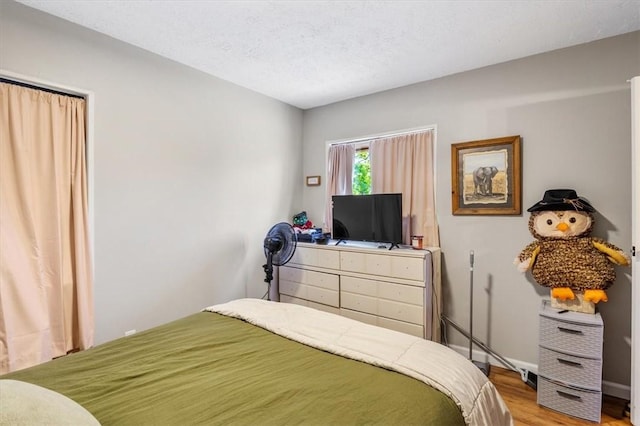 bedroom featuring hardwood / wood-style flooring and a textured ceiling