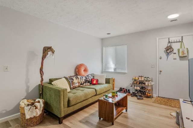 living room with light hardwood / wood-style flooring and a textured ceiling