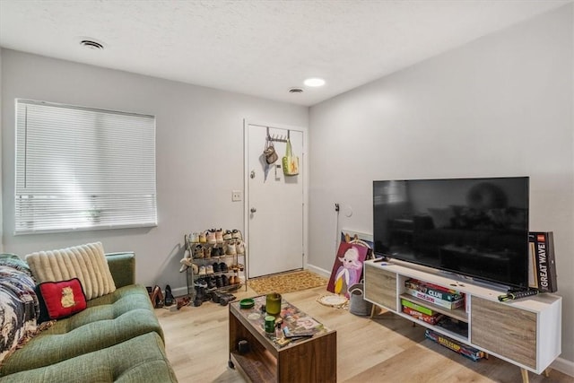 living room featuring a textured ceiling and light hardwood / wood-style floors